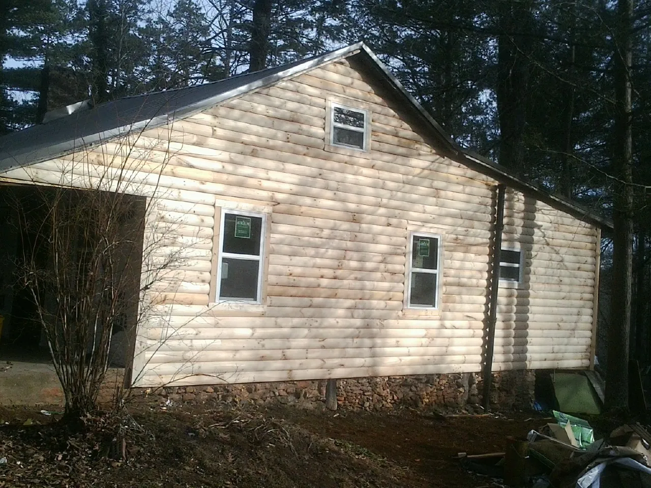New log siding and dark metal roofing on a gable end in Lake Ariel
