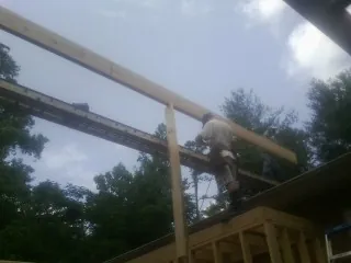 Carpenter setting a ridge beam over a new addition frame — Ice Dam Removal by Roofing Brothers in Lake Ariel