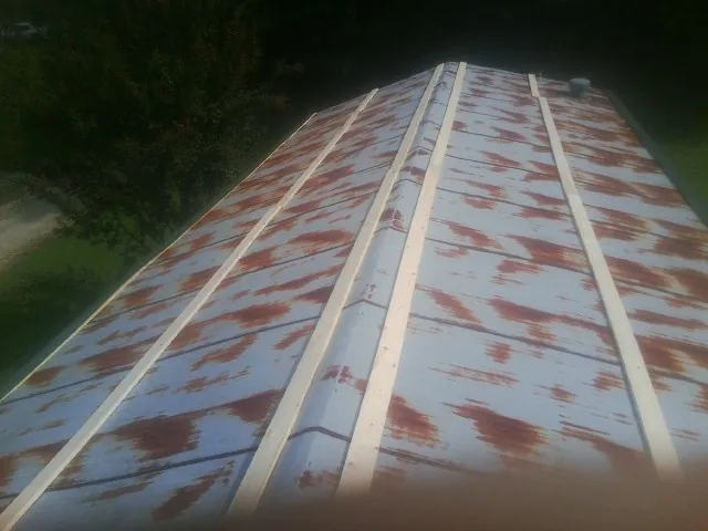 Rusted metal roof panels with new wood purlins before replacement — Storm Damage Roof Repair in Lake Ariel by Roofing Brothers