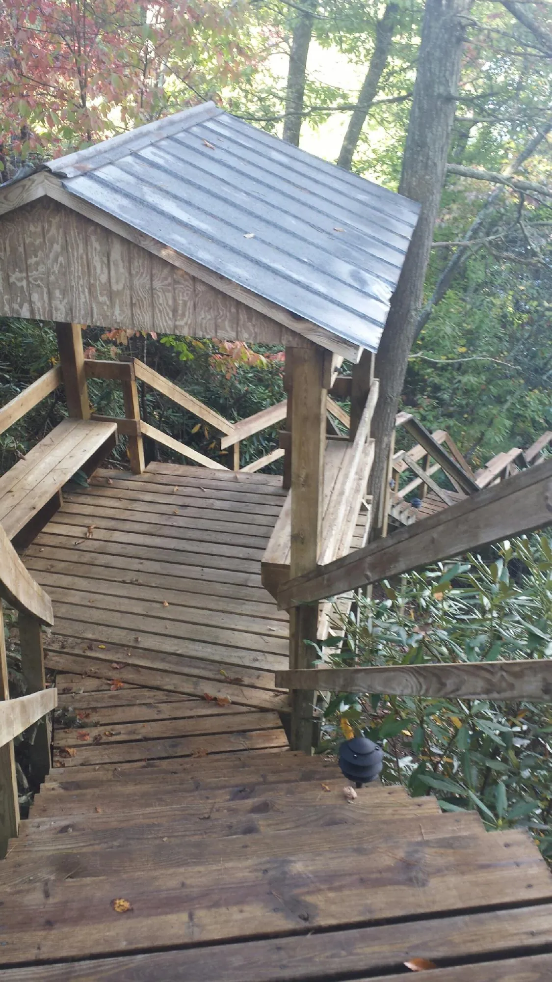 Metal roofed shelter over wooden steps on a wooded walkway — Skylight Repair & Installation work by our crew in Lake Ariel