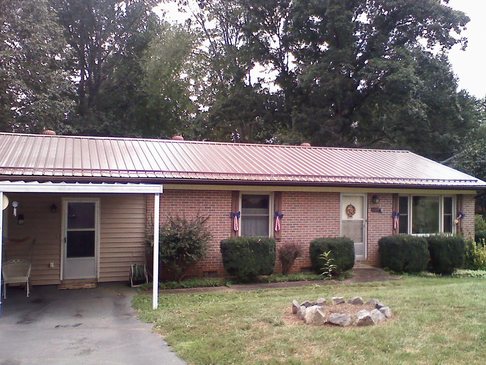 Bronze metal roof and carport on a brick ranch home — Roof Repair work by our crew in Lake Ariel